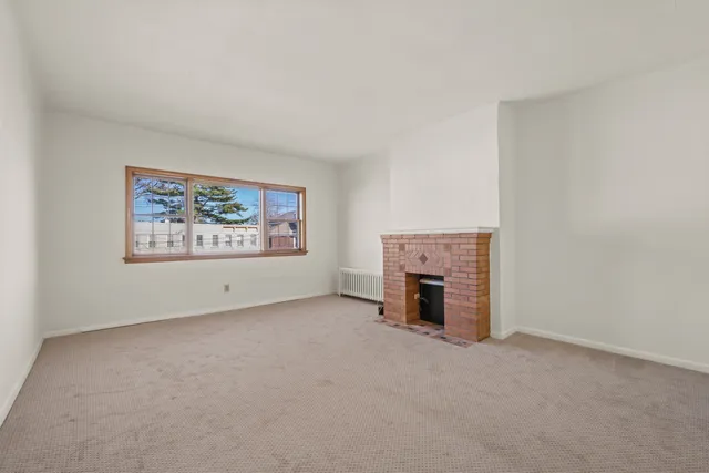 an empty room with furniture and a fireplace