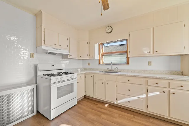 a kitchen with granite countertop white cabinets and white appliances