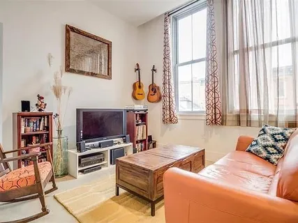 a living room with furniture a flat screen tv and a window