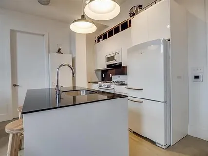 a kitchen with stainless steel appliances a sink and a refrigerator