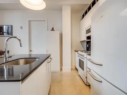 a kitchen with kitchen island granite countertop a sink stainless steel appliances and cabinets