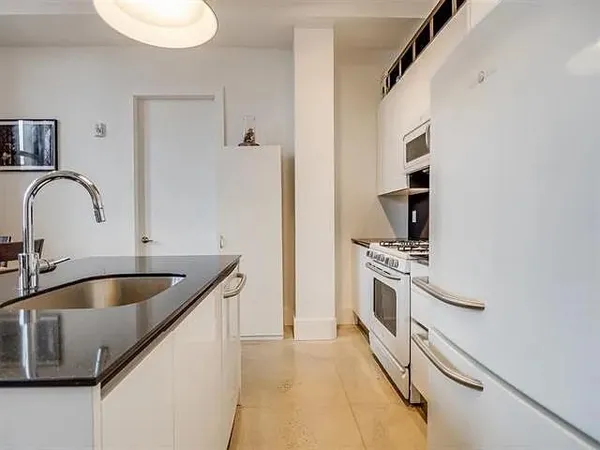 a kitchen with kitchen island granite countertop a sink stainless steel appliances and cabinets