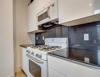 a stove top oven sitting inside of a kitchen