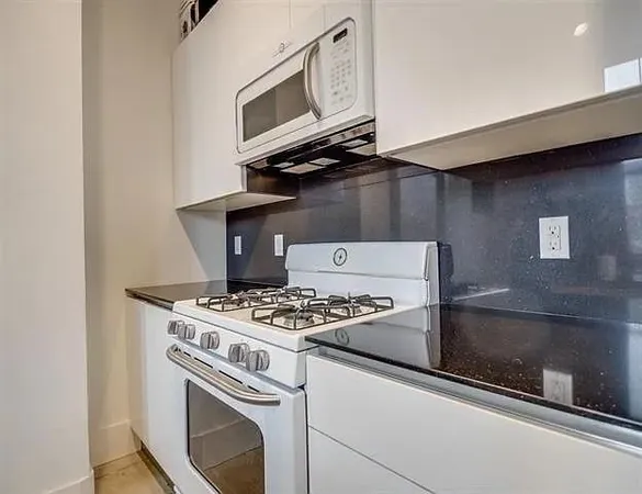 a stove top oven sitting inside of a kitchen