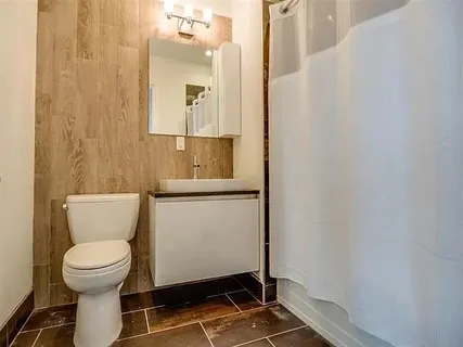 a bathroom with a toilet and a mirror