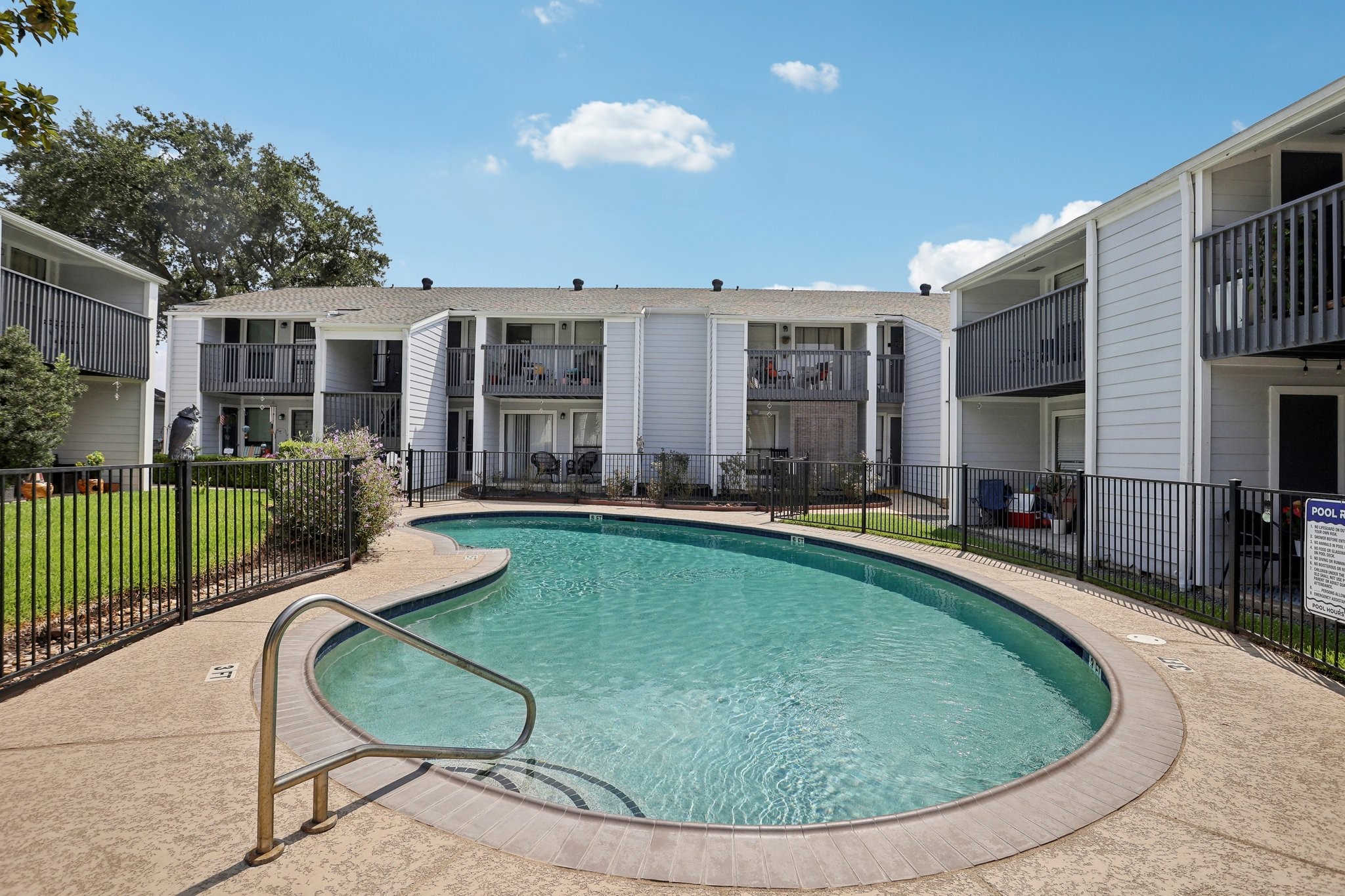 13151 Walden Road, Unit 136 Montgomery, TX 77356 - Photo 14 of 17 This is a well-maintained condo complex with a central communal swimming pool, surrounded by two-story buildings with private balconies and external staircases.