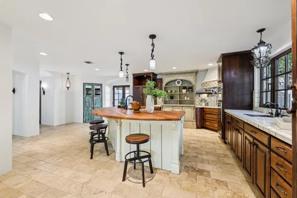 a dining hall with stainless steel appliances kitchen island granite countertop a dining table and chairs