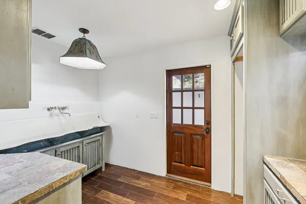 a kitchen with a wooden floor and a window