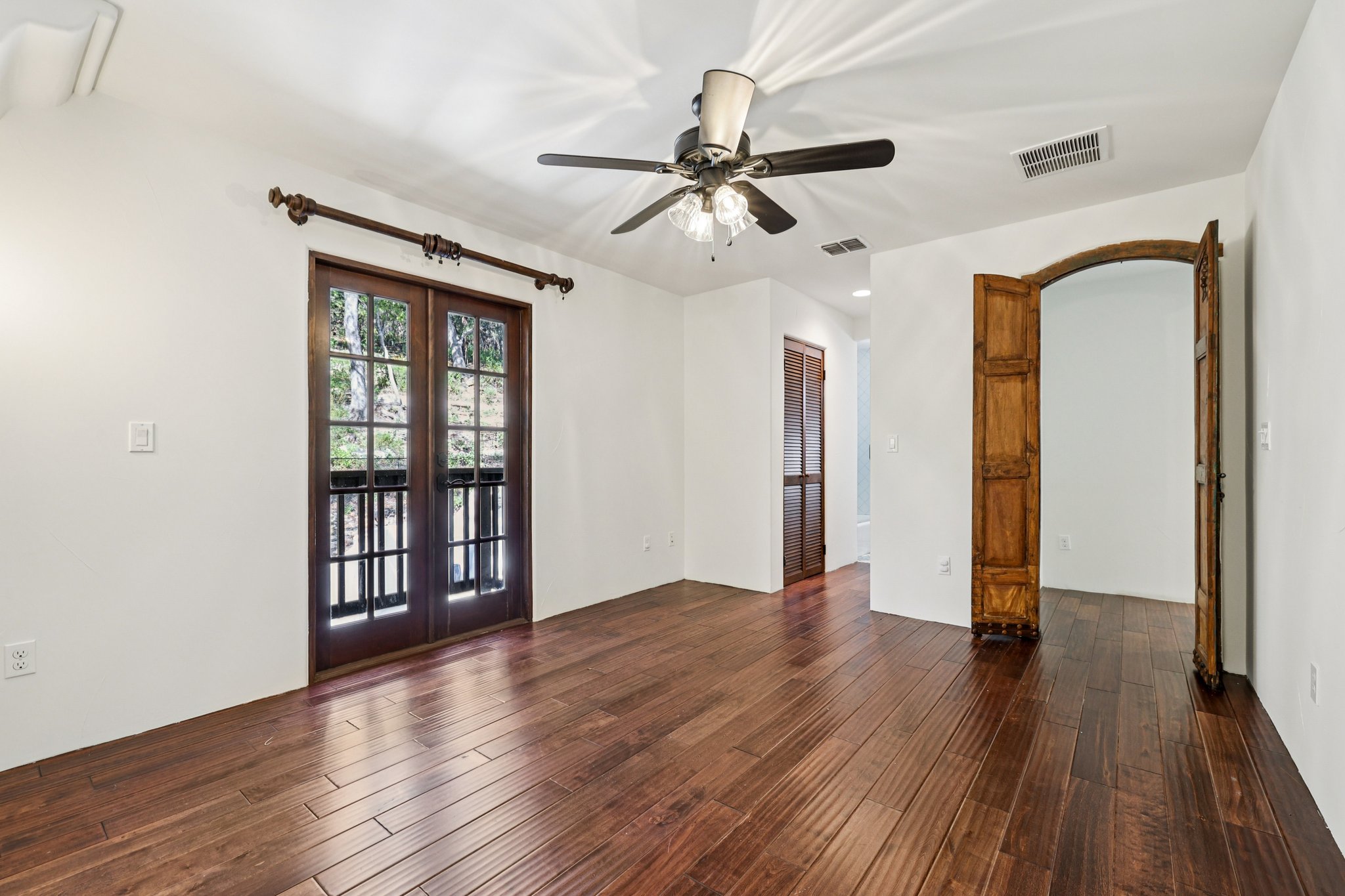 2706 Pearce Road Austin, TX 78730 - Photo 22 of 37 a view of an empty room with wooden floor and a ceiling fan