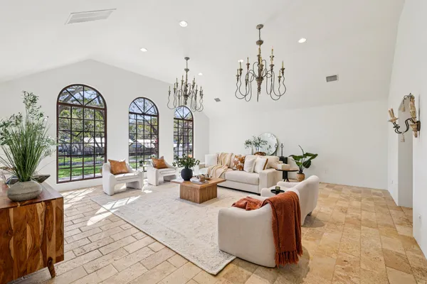 a living room with patio furniture and a chandelier