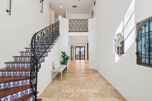 a hallway with a large entryway and paintings on the wall