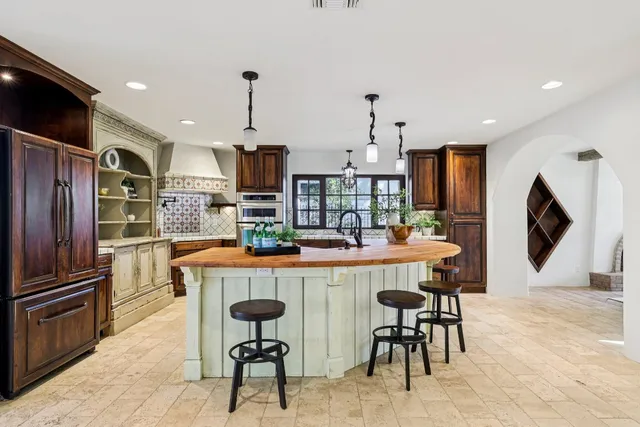 a kitchen with refrigerator and chairs