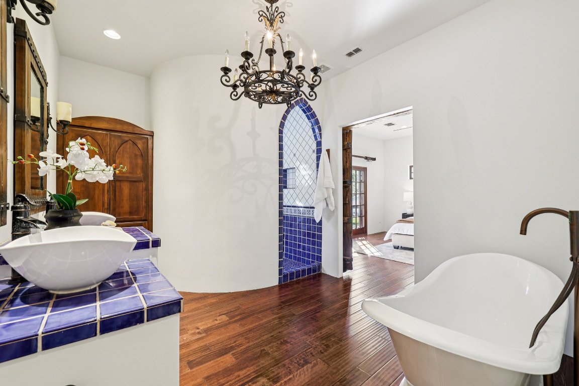 2706 Pearce Road Austin, TX 78730 - Photo 8 of 38 Primary Bathroom: Spa-inspired primary bath featuring vibrant custom tile work.
Soaking Tub: Relax in the freestanding soaking tub, a centerpiece of the en suite bath.