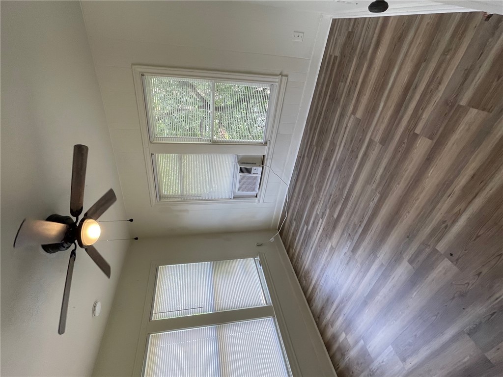 408 Hill Street Bryan, TX 77803 - Photo 12 of 13 an empty room with wooden floor chandelier fan and windows