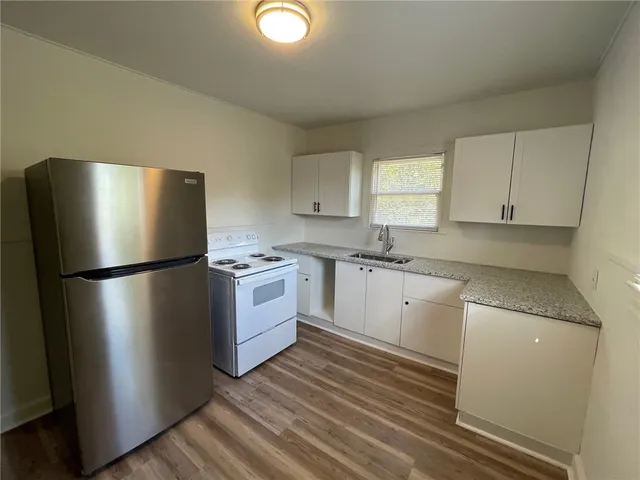 a kitchen with a refrigerator sink and cabinets
