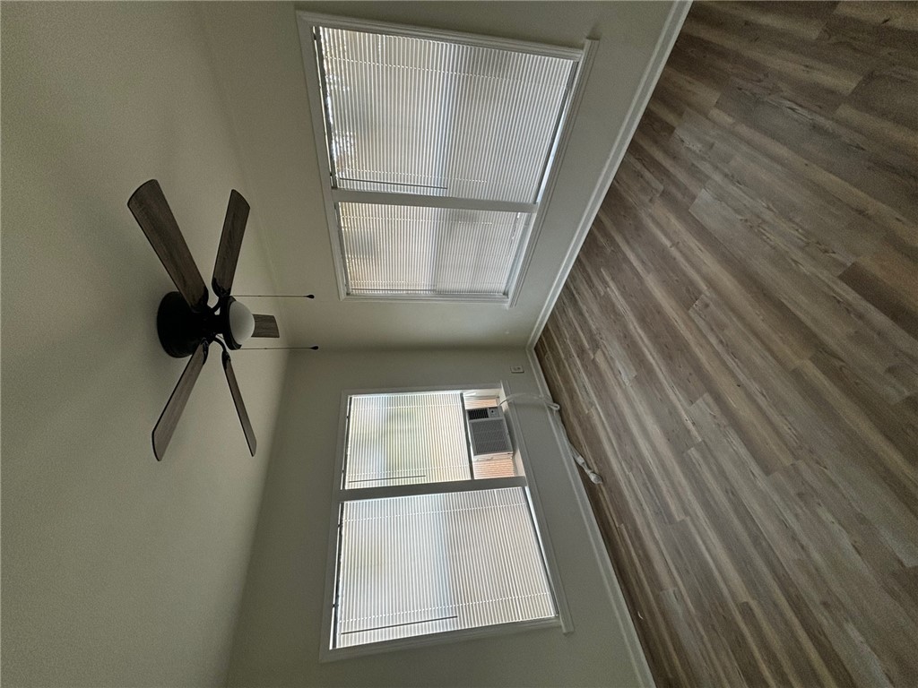 408 Hill Street Bryan, TX 77803 - Photo 6 of 13 an empty room with wooden floor fan and windows
