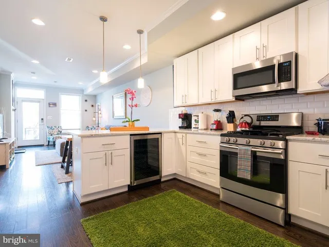 a kitchen with stainless steel appliances granite countertop a stove a sink and a microwave
