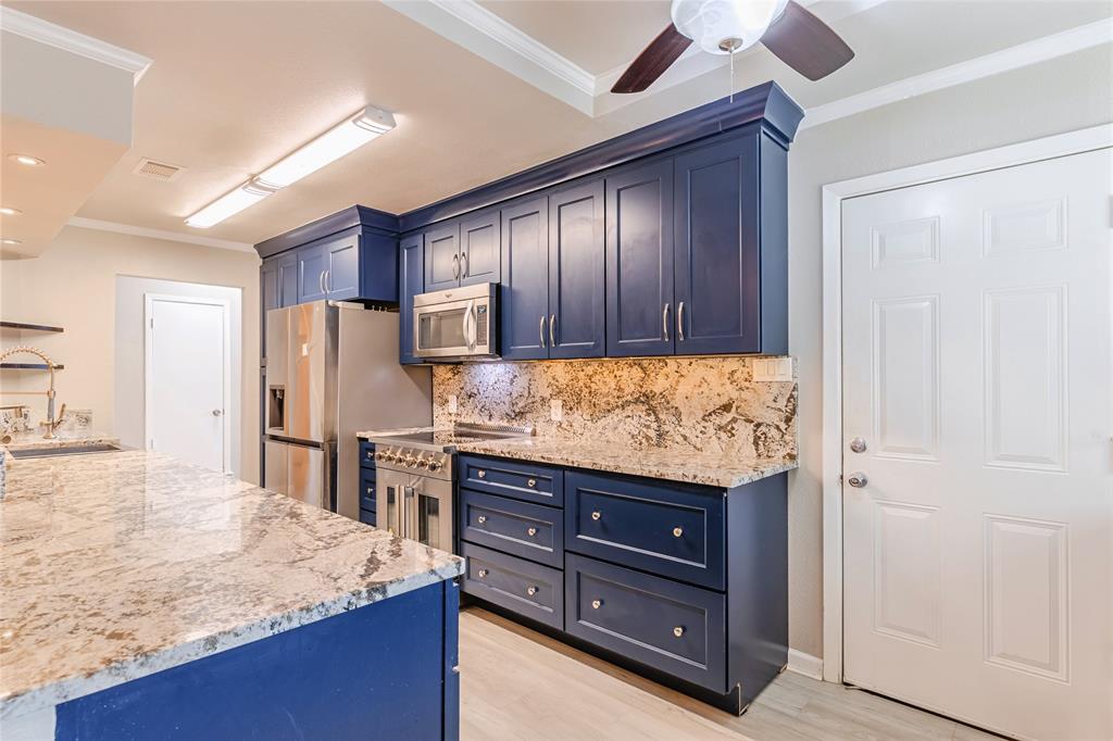 6501 Patsy Lane Watauga, TX 76148 - Photo 9 of 24 a kitchen with granite countertop wooden cabinets and refrigerator
