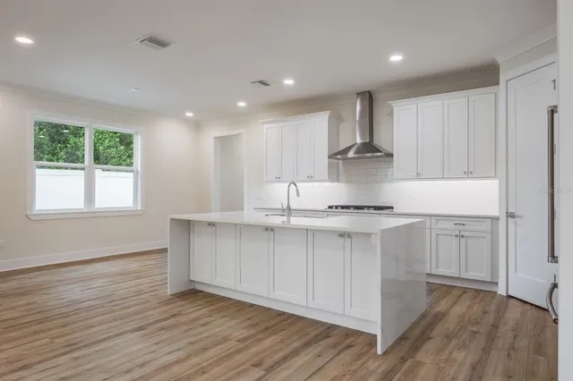 a kitchen with kitchen island white cabinets and stainless steel appliances