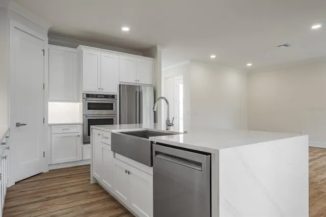 a kitchen with white cabinets and a stove top oven