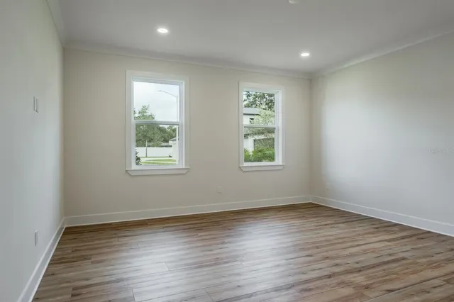 a view of an empty room with wooden floor