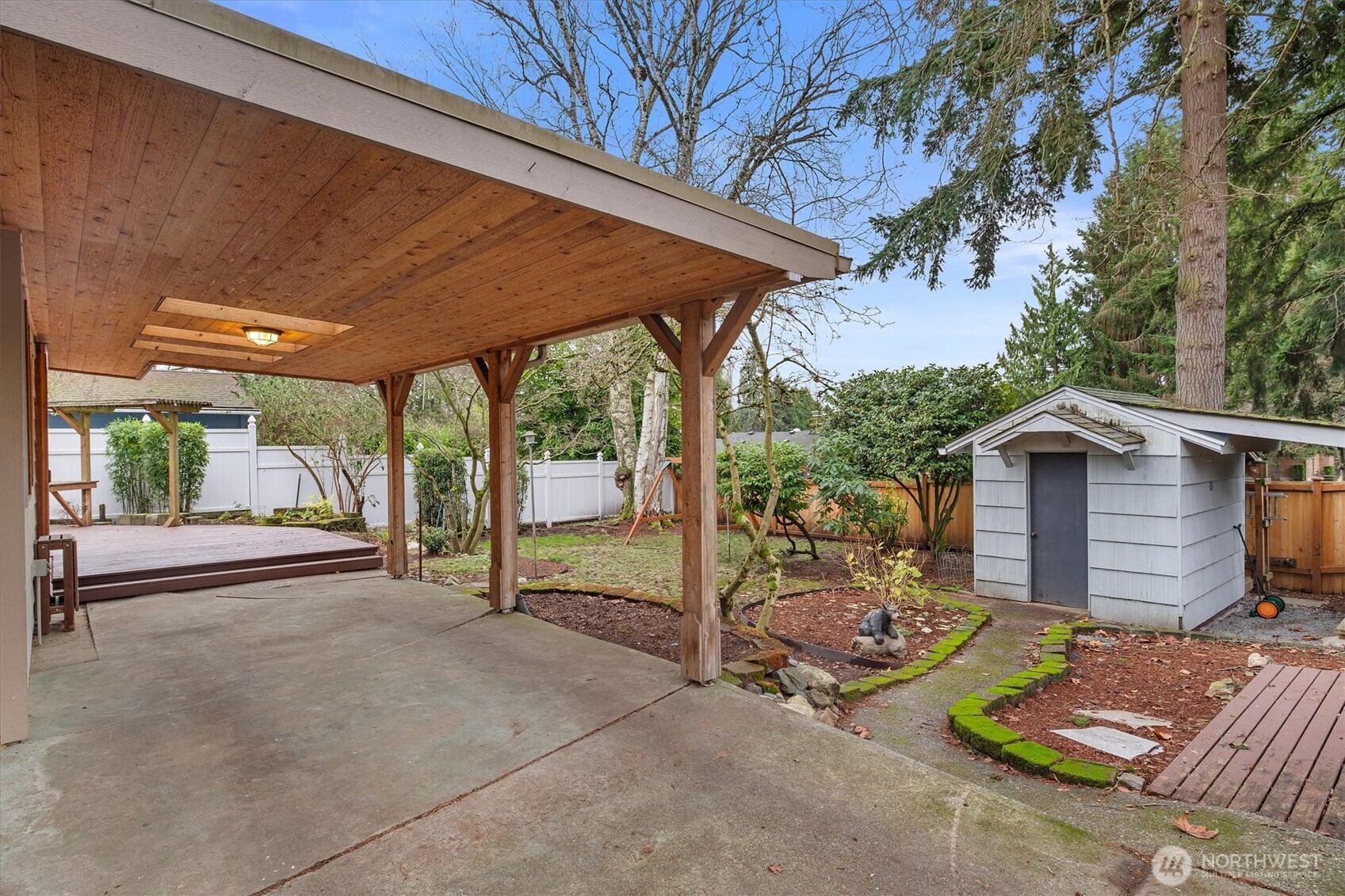 15760 Meridian Avenue North Shoreline, WA 98133 - Photo 21 of 26 a view of a patio with table and chairs under an umbrella with a ceiling fan