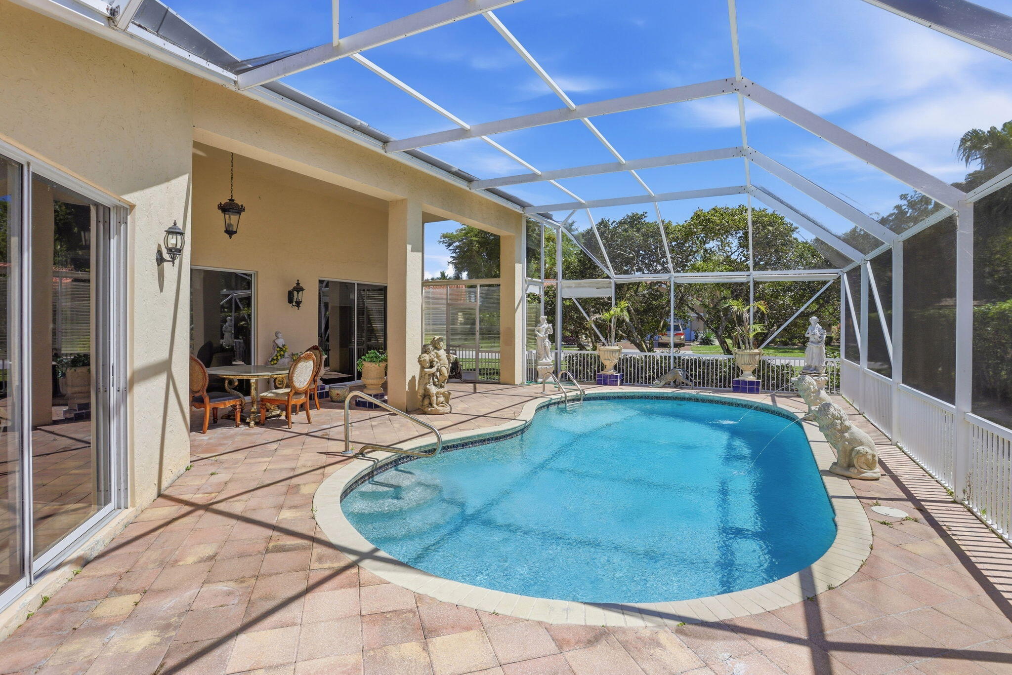 7821 Dorchester Road Boynton Beach, FL 33472 - Photo 1 of 49 a view of a patio with table and chairs under an umbrella
