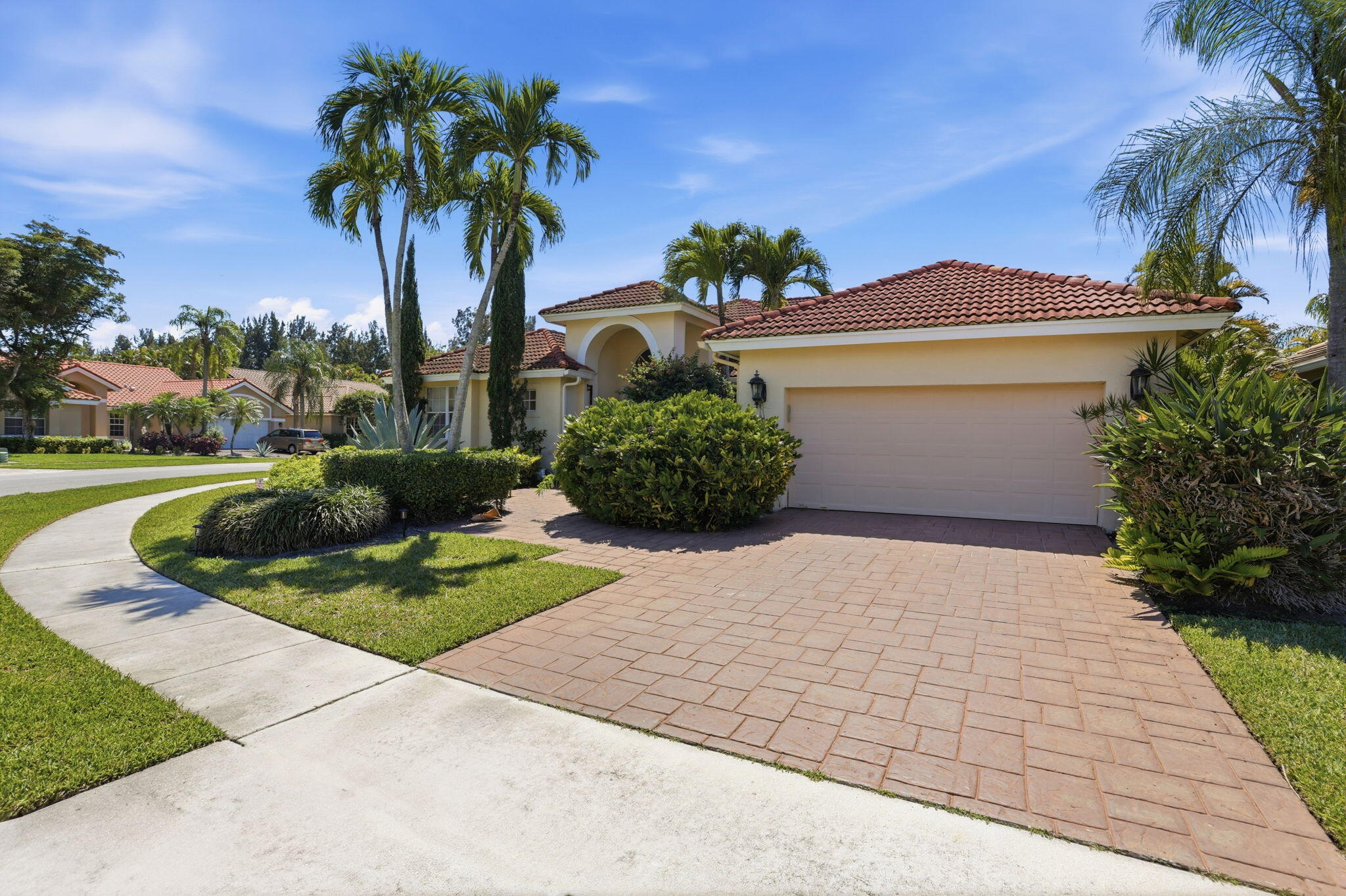 7821 Dorchester Road Boynton Beach, FL 33472 - Photo 2 of 49 a front view of a house with garden and plants