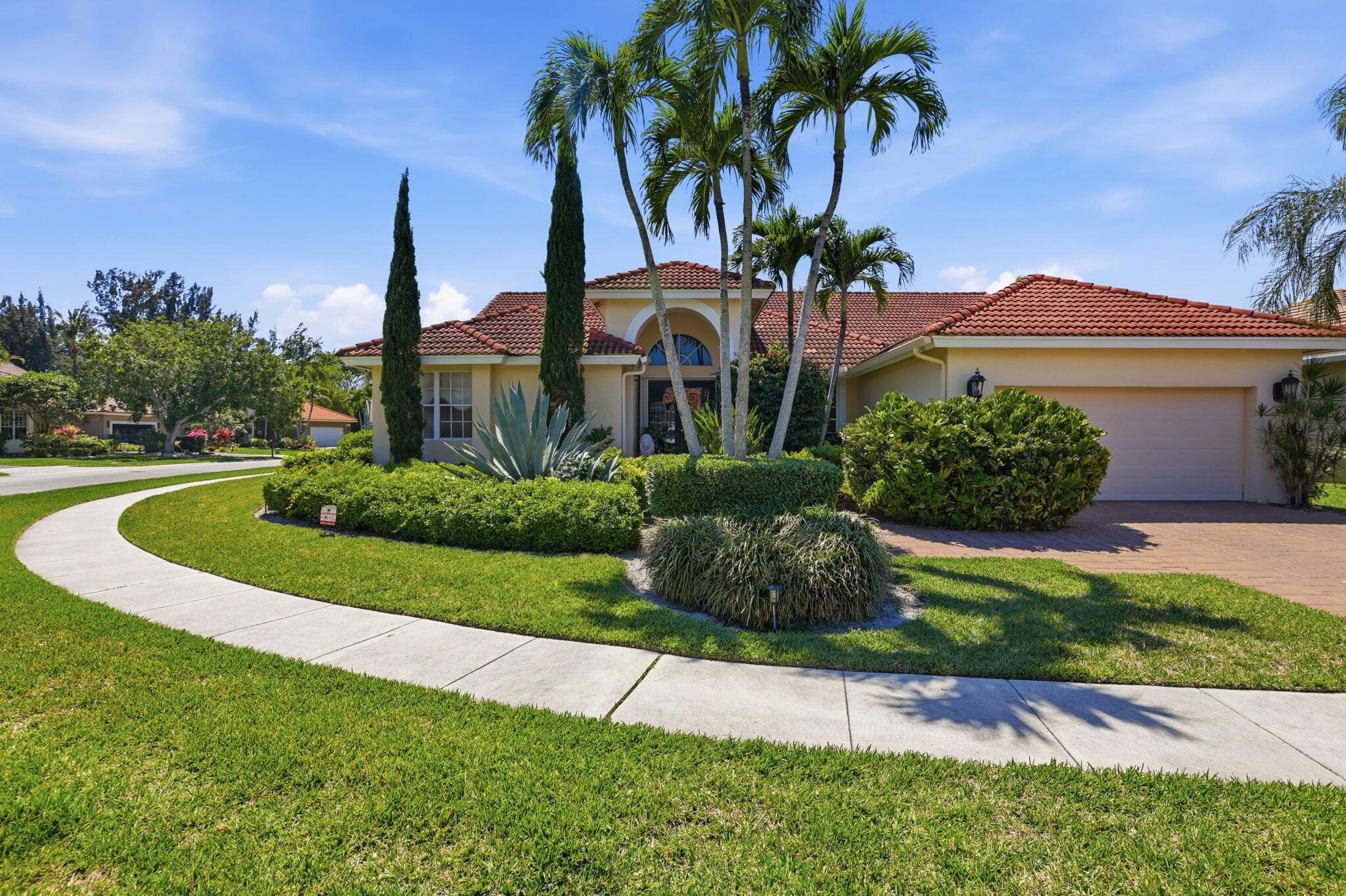 7821 Dorchester Road Boynton Beach, FL 33472 - Photo 3 of 49 a front view of a house with a yard and potted plants