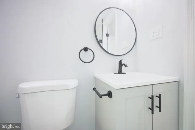 a bathroom with a sink a toilet and a mirror