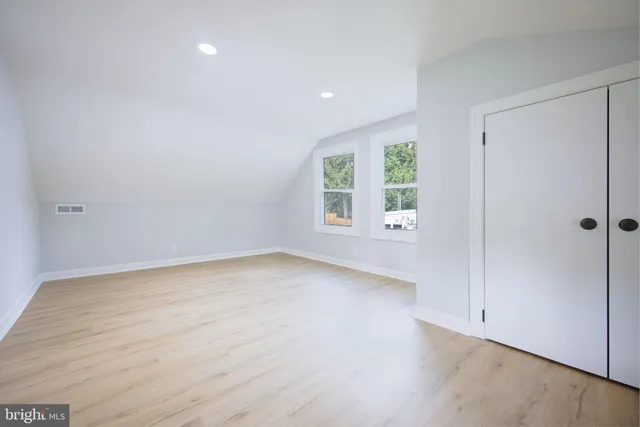an empty room with wooden floor and window