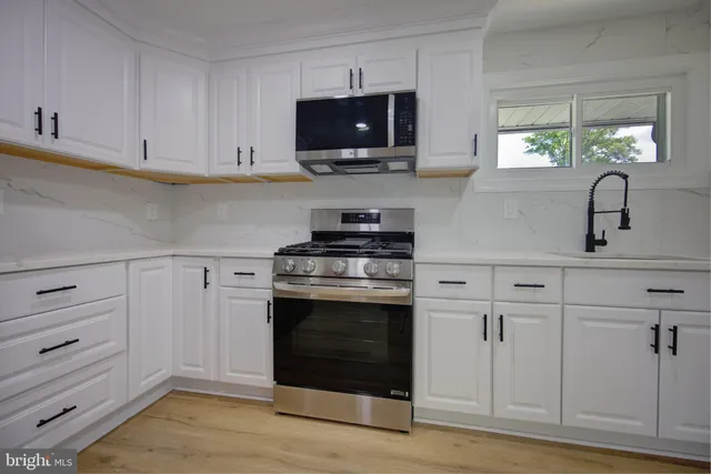 a kitchen with white cabinets and stainless steel appliances