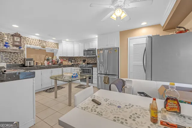 a kitchen with stainless steel appliances kitchen island granite countertop a refrigerator and a stove top oven
