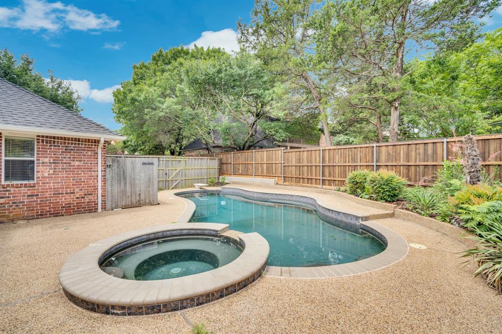 1907 Timber Ridge Court Cedar Hill, TX 75104 - Photo 27 of 30 Backyard featuring a freeform swimming pool and integrated spa, surrounded by aggregate concrete decking