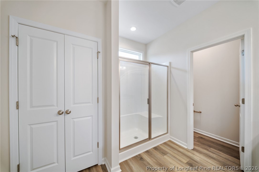 4052 Lofton Street Wade, NC 28395 - Photo 19 of 22 a view of a bathroom with a glass door and mirror