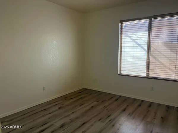 a view of a room that has wooden floor and windows