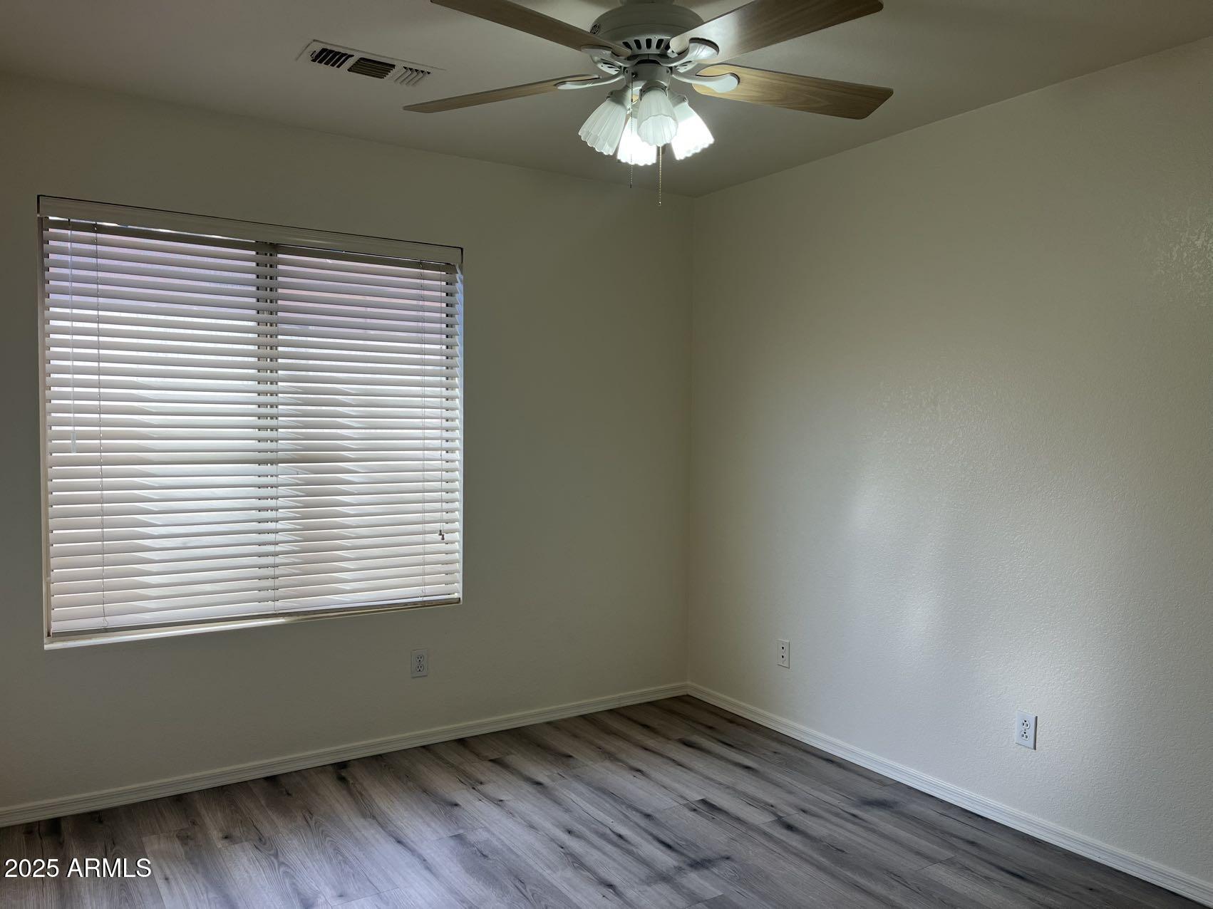1128 East Sheffield Avenue Gilbert, AZ 85296 - Photo 12 of 24 a view of an empty room with wooden floor and a window