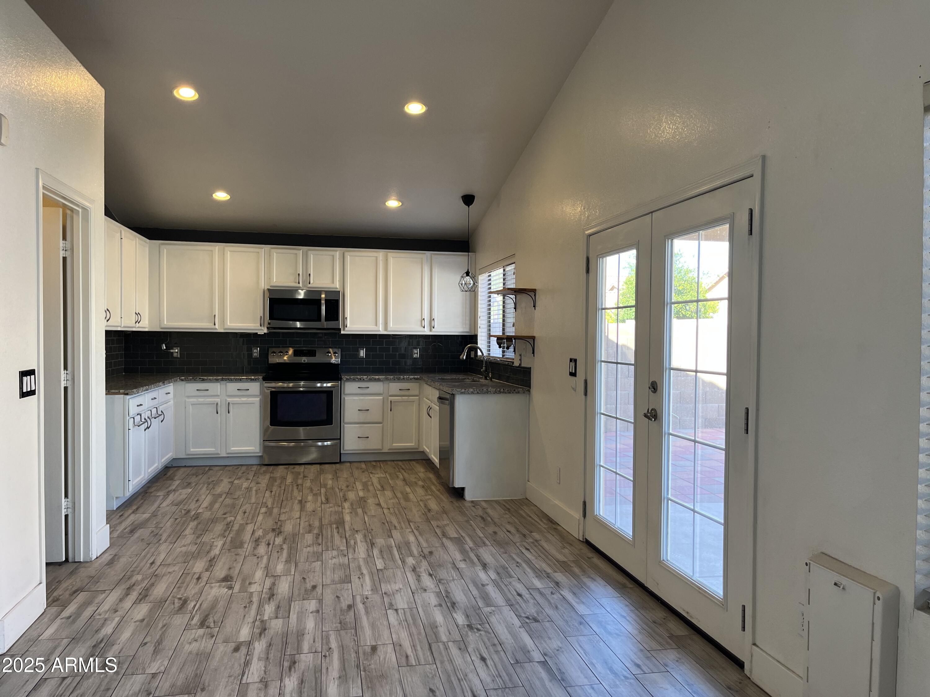 1128 East Sheffield Avenue Gilbert, AZ 85296 - Photo 6 of 24 a kitchen with a refrigerator and a stove top oven