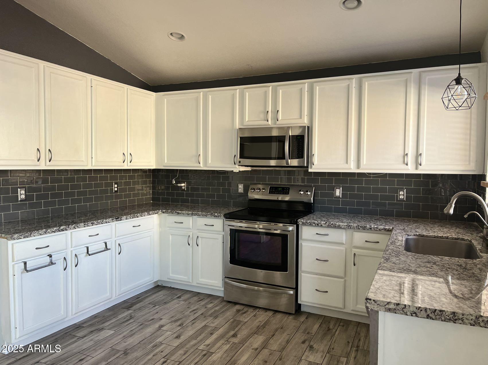 1128 East Sheffield Avenue Gilbert, AZ 85296 - Photo 7 of 24 a kitchen with granite countertop a sink a stove and cabinets