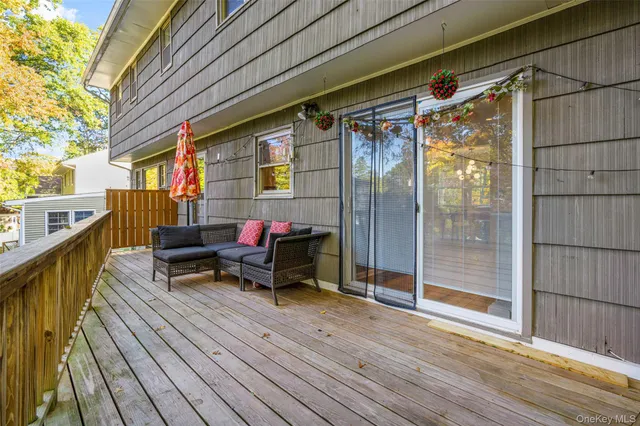 a balcony with wooden floor table and chairs