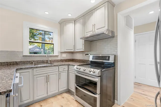 a kitchen with white cabinets and appliances