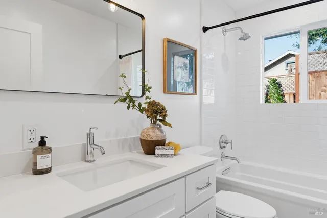 a bathroom with a granite countertop sink a toilet and shower