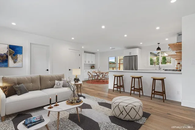 a living room with furniture and a wooden floor