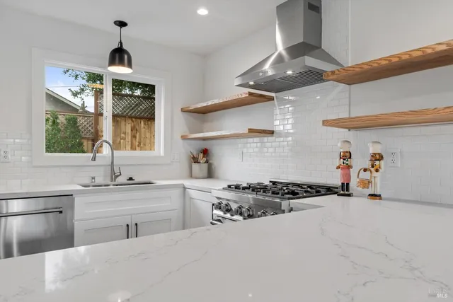 a kitchen with stainless steel appliances granite countertop a sink stove and cabinets