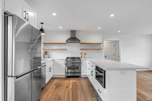 a kitchen with stainless steel appliances granite countertop a stove and a refrigerator