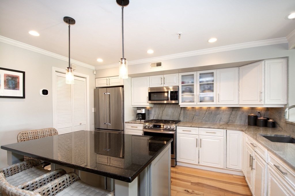 16 Ladds Way, Unit 16 Scituate, MA 02066 - Photo 14 of 40 a kitchen with stainless steel appliances granite countertop a sink refrigerator and cabinets