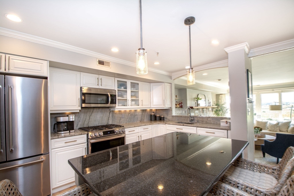 16 Ladds Way, Unit 16 Scituate, MA 02066 - Photo 15 of 40 a kitchen with stainless steel appliances granite countertop a refrigerator a sink a stove and white cabinets