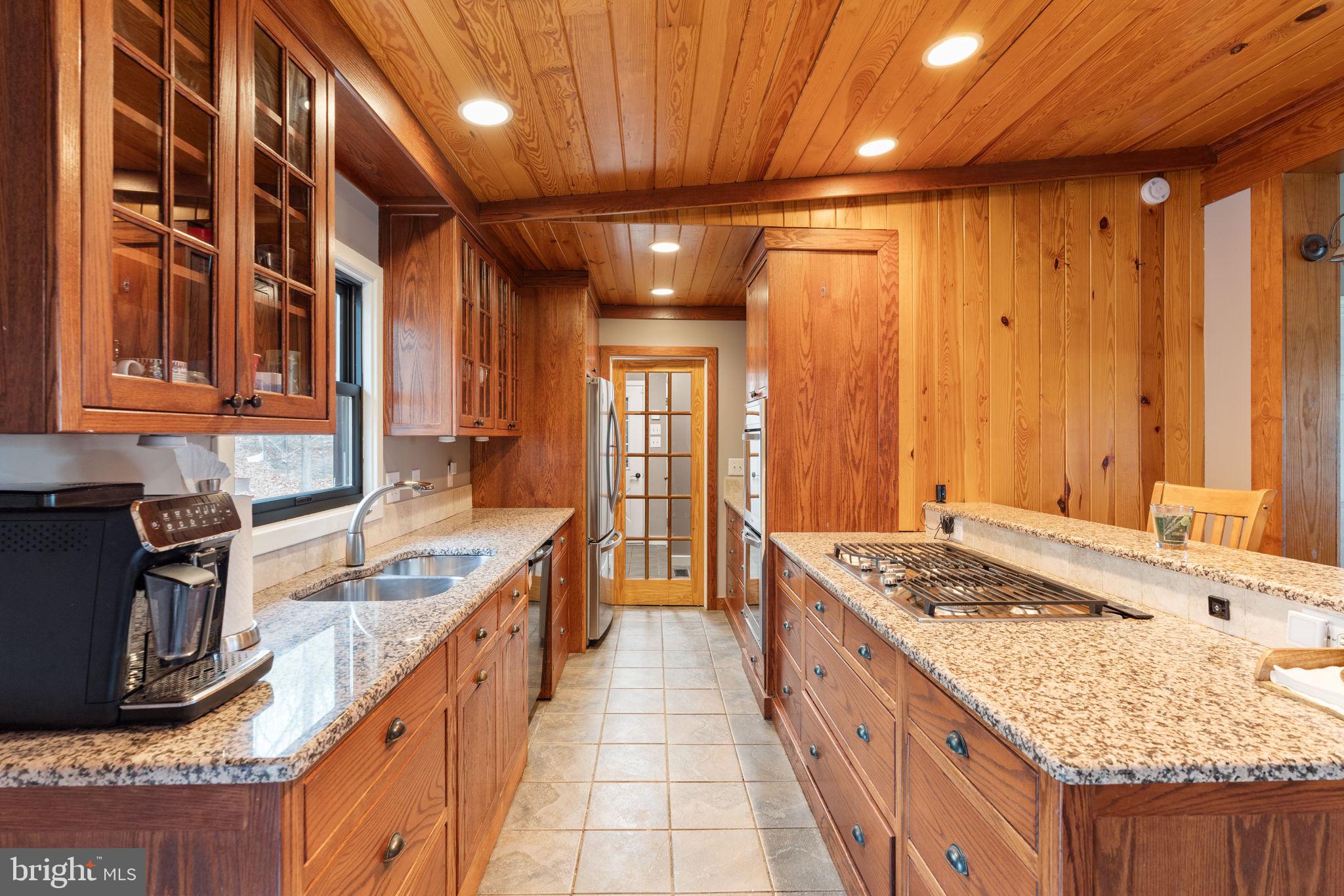 4098 Mountain Road Haymarket, VA 20169 - Photo 16 of 49 a large kitchen with kitchen island granite countertop a sink and wooden cabinets