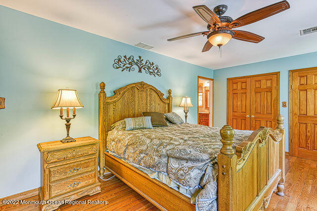 340 East Millstream Road Cream Ridge, NJ 08514 - Photo 23 of 40 a bedroom with a bed and a chandelier