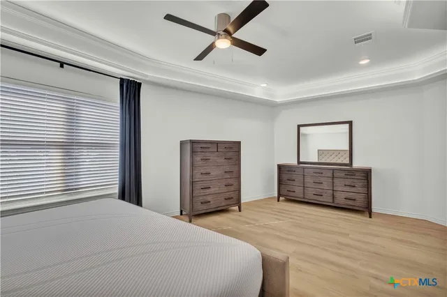 a bedroom with a bed dresser and a window